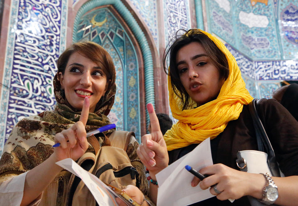 <p>Iranian girls show ink on their fingers after casting their ballot during the Iranian presidential elections at a polling station in Tehran, Iran, May 19, 2017. Out of the candidates, the race is tightest between frontrunners Iranian current president Hassan Rouhani and conservative presidential candidate Ebrahim Raisi. (Photo: Abedin Taherkenareh/EPA) </p>