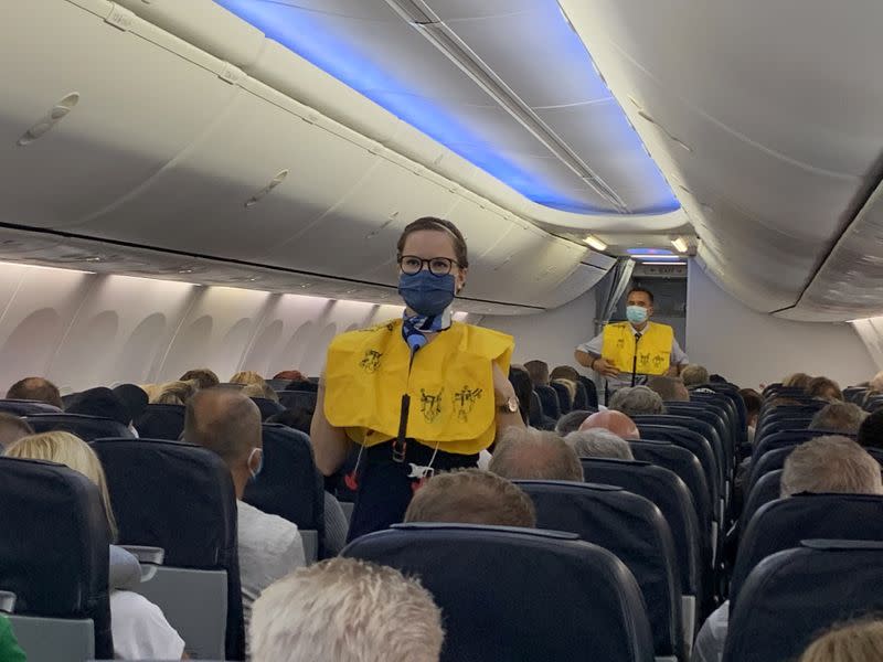 Las azafatas de TUI Fly usan mascarillas mientras dan instrucciones a los turistas alemanes en el primer vuelo de Dusseldorf a Mallorca en Dusseldorf, Alemania, el 15 de junio de 2020