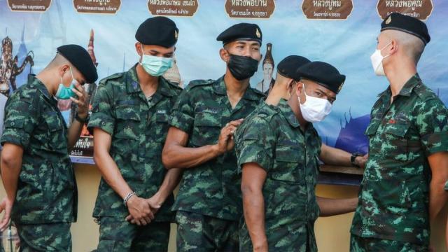 Members of the Thai military line up at a polling station.