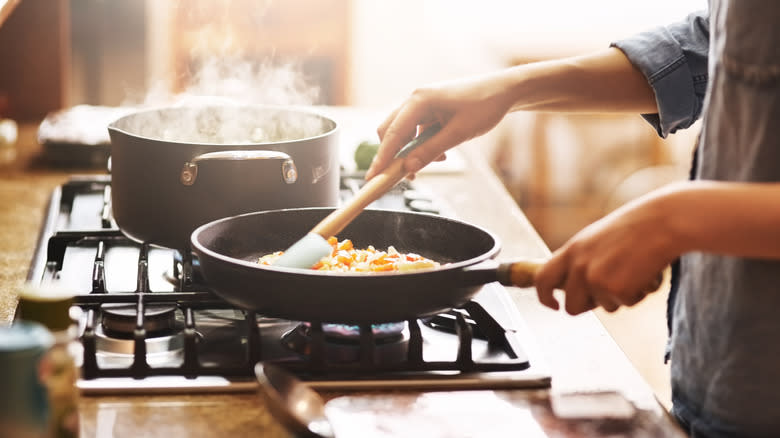 person cooking food in skillet