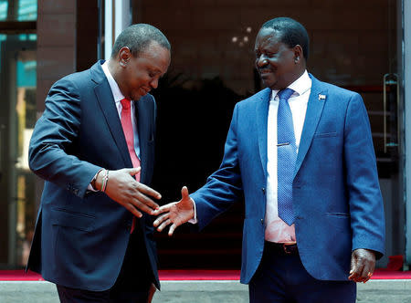 FILE PHOTO: Kenya's President Uhuru Kenyatta (L) greets opposition leader Raila Odinga of the National Super Alliance (NASA) coalition after addressing a news conference at the Harambee house office in Nairobi, Kenya March 9, 2018. REUTERS/Thomas Mukoya/File Photo