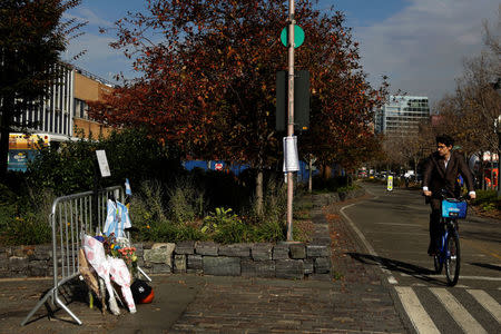 A bicyclist passes a memorial on West Street two days after a man driving a rented pickup truck mowed down pedestrians and cyclists on a bike path alongside the Hudson River, in New York, U.S., November 2, 2017. REUTERS/Lucas Jackson