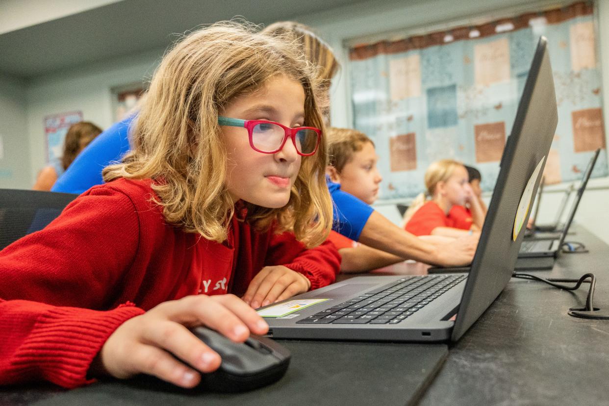 Third grade students work Monday in the computer lab at Holy Spirit Catholic School with teachers Carla Redmond and Jeanne Minchew.