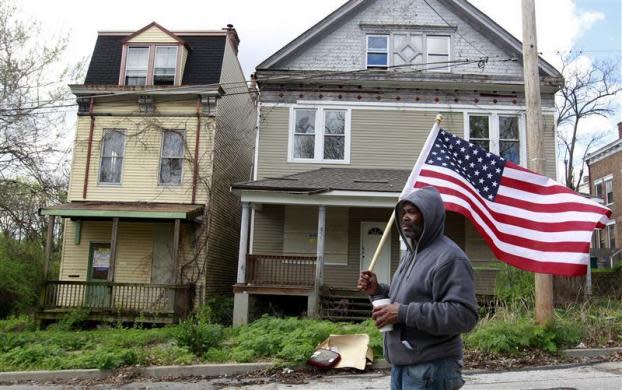 Reginald Hill of Occupy Cincinnati and Occupy the Hood joins a march to protest home foreclosures in the East Price Hill neighborhood in Cincinnati, Ohio March 24, 2012. Occupy activists across America say they have found a cause that represents an issue for the "99 percent" and embodies the movement's anti-Wall Street message: helping struggling homeowners fight foreclosure and eviction. Picture taken March 24, 2012.