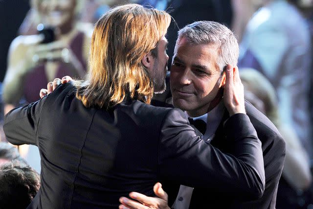 <p>Kevin Winter/Getty</p> Brad Pitt and George Clooney in 2012