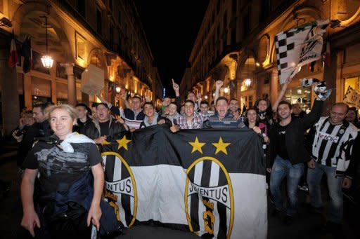 Juventus' supporters celebrate on May 6, in central Turin, at the end of the Serie A match Juventus against Cagliari held at Nereo Rocco stadium in Trieste. Juventus won the match 2-0 to win the Italian championship