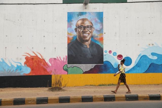 FILE PHOTO: A woman walks past a graffiti depicting Labour Party (LP) Presidential candidate, Peter Obi, ahead of Nigeria's Presidential election in Awka