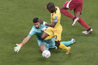 Ecuador's Enner Valencia, centre, is fouled by Qatar's goalkeeper Saad Al Sheeb, left, during the World Cup group A soccer match between Qatar and Ecuador at the Al Bayt Stadium in Al Khor, Qatar, Sunday, Nov. 20, 2022. (AP Photo/Hassan Ammar)