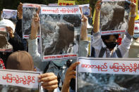 Mandalay University graduates hold posters with an image of Mya Thwate Thwate Khaing, a 19-year old woman shot by police on Feb. 9 in Naypyitaw, during an anti-coup protest in Mandalay, Myanmar, Sunday, Feb. 14, 2021. Daily mass street demonstrations in Myanmar are on their second week, with neither protesters nor the military government they seek to unseat showing any signs of backing down from confrontations. (AP Photo)