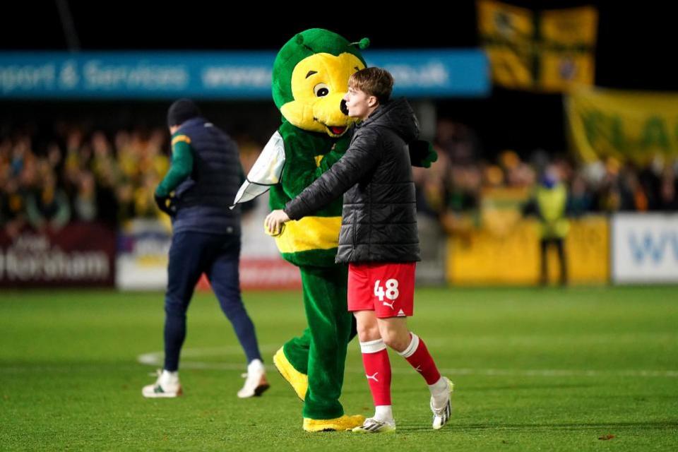 The Bolton News: Ex-Bolton midfielder Luca Connell - now at Barnsley - shakes hands with Horsham's mascot in the FA Cup