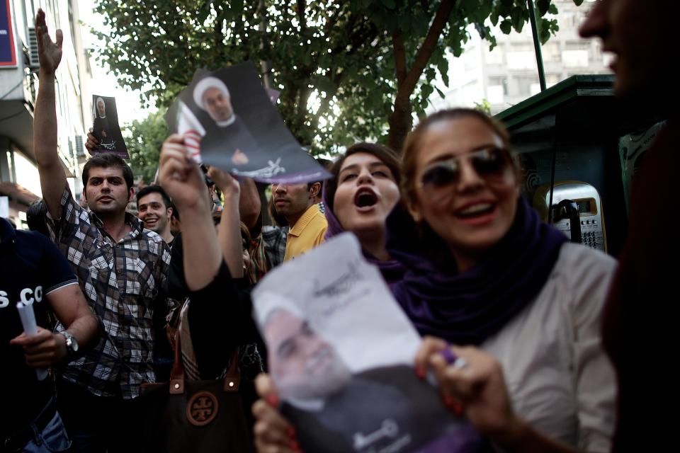 Iranian women hold a portrait of moderate presidential candidate Hassan Rouhani who won the national election in downtown Tehran on June 15, 2013. (BEHROUZ MEHRI/AFP/Getty Images)