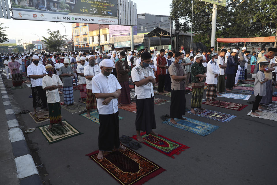 Indonesian Muslims wearing face masks perform an Eid al-Fitr prayer that marks the end of the holy fasting month of Ramadan amid fears of the new coronavirus outbreak at a mosque in Bekasi on the outskirts of Jakarta, Indonesia Sunday, May 24, 2020. Millions of people in the world's largest Muslim nation are marking a muted and gloomy religious festival of Eid al-Fitr, the end of the fasting month of Ramadan - a usually joyous three-day celebration that has been significantly toned down as coronavirus cases soar. (AP Photo/Achmad Ibrahim)