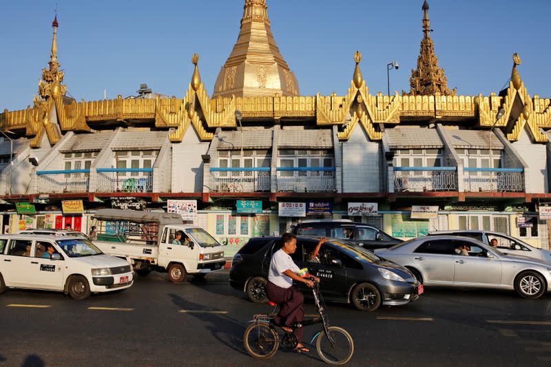 FILE PHOTO: A man rides his bicycle past Sule Pagoda in Yangon