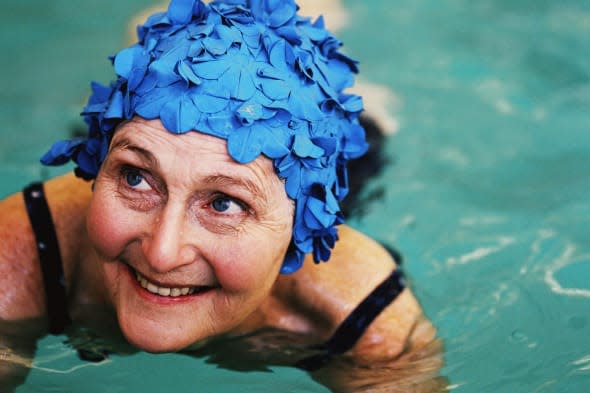 high angle view of an elderly woman in the swimming pool; smiling