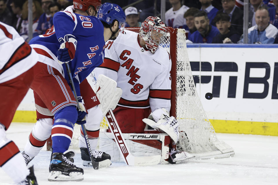 Carolina Hurricanes goaltender Frederik Andersen, right, and New York Rangers left wing Chris Kreider (20) watch the puck go wide of the net in the first period during Game 5 of an NHL hockey Stanley Cup second-round playoff series Monday, May 13, 2024, in New York. (AP Photo/Adam Hunger)