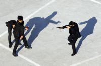 Trainees point replica pistols as they take part in a training session at the Tianjiao Special Guard/Security Consultant training camp on the outskirts of Beijing, December 11, 2013. Former Chinese soldier Chen Yongqing has big ambitions for his bodyguard training school Tianjiao, which he says is China's first professional academy to train former soldiers and others as personal security guards. Chen charges 500,000 yuan ($82,400) a year for each protector as China's rich and famous look to bolster their safety and sense of importance. Picture taken December 11, 2013. REUTERS/Jason Lee (CHINA - Tags: BUSINESS SOCIETY TPX IMAGES OF THE DAY) ATTENTION EDITORS: PICTURE 01 OF 26 FOR PACKAGE 'CHINA'S BODYGUARD SCHOOL' TO FIND ALL IMAGES SEARCH 'TIANJIAO'