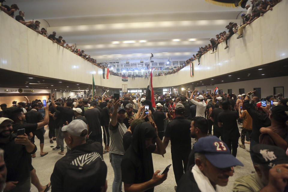 Iraqi protesters fill the Parliament building in Baghdad, Iraq, Saturday, July 30, 2022 as thousands of followers of an influential Shiite cleric breached the building for the second time in a week to protest the government formation efforts lead by Iran-backed groups.(AP Photo/Anmar Khalil)