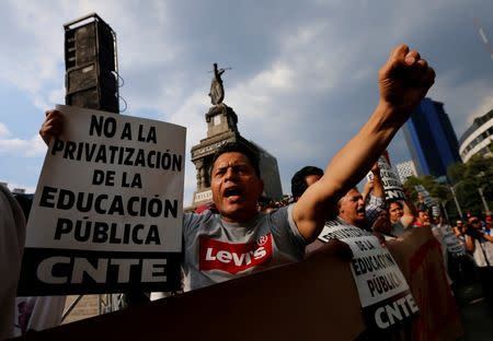 Protesters from the National Coordination of Education Workers (CNTE) teachers' union holds signs in a march against President Enrique Pena Nieto's education reform, along the streets in Mexico City, Mexico June 17, 2016. REUTERS/Henry Romero