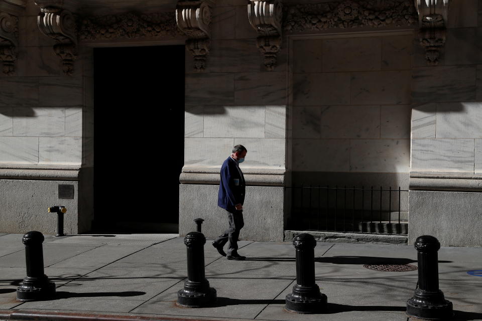 A trader wearing a protective face mask walks, as the global outbreak of the coronavirus disease (COVID-19) continues, at the New York Stock Exchange (NYSE) in the financial district of New York, U.S., November 19, 2020. REUTERS/Shannon Stapleton