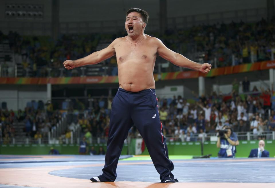 <p>The coach of Mandakhnaran Ganzorig (MGL) of Mongolia protests against the result of the match with Ikhtiyor Navruzov (UZB) of Uzbekistan by taking off his clothes. (Reuters) </p>