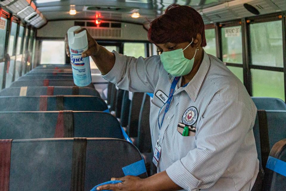Palm Beach County School bus driver Nadine Cousins sanitizes the seats of her school bus after dropping off students at Lincoln Elementary School in Riviera Beach, in 2020.
