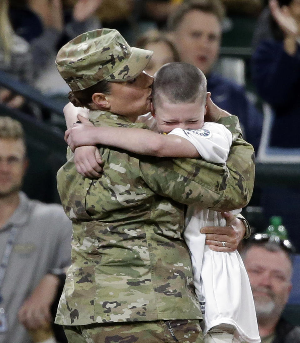 <p>U.S. Army Reserve Sgt. 1st Class Heather Moran, returning from an 11-month deployment, surprises her son Ryan Payne, 11, between innings during a baseball game between the Seattle Mariners and Oakland Athletics Friday, April 8, 2016, in Seattle. The surprise reunion was a part of the Mariners’ program that honors members of the military for their service. (AP Photo/Elaine Thompson) </p>