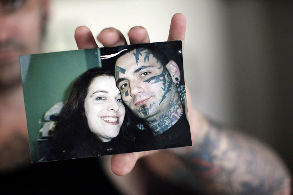 <p>In this Aug. 2, 2011 photo, former skinhead Bryon Widner holds a photo at his home of him and his wife Julie Larsen taken before his facial tattoos were removed. After getting married in 2006, the couple, former pillars of the white power movement (she as a member of the National Alliance, he a founder of the Vinlanders gang of skinheads) had worked hard to put their racist past behind them. They had settled down and had a baby; her younger children had embraced him as a father. But leaving the old life would not be easy when it was all he had known – and when his face remained a billboard of hate. (Photo: Jae C. Hong/AP) </p>