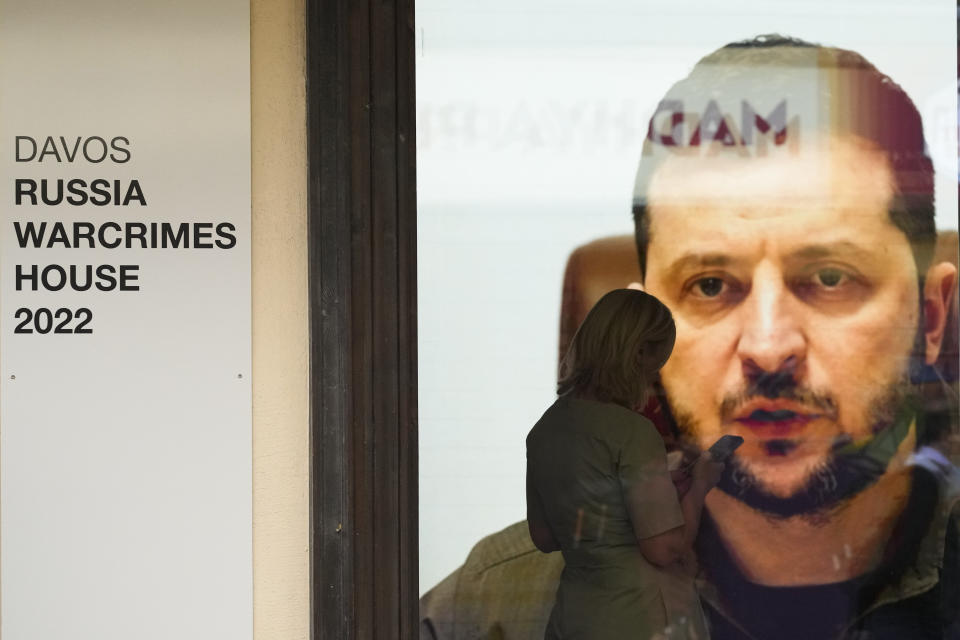 Ukrainian President Volodymyr Zelenskyy speaks on a screen inside a so-called Russian War Crimes House alongside the World Economy Forum in Davos, Switzerland, Sunday, May 22, 2022. An exhibition with pictures documenting suspected Russian war crimes in the Ukrainian war are to be shown in the house. The annual meeting of the World Economy Forum is taking place in Davos from May 22 - 26. (AP Photo/Markus Schreiber)