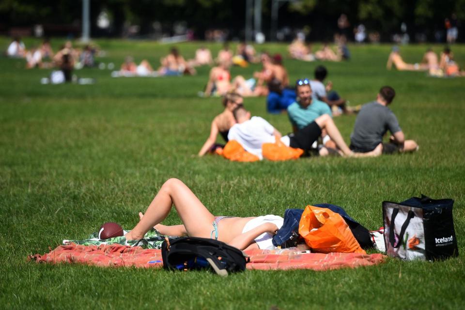 People enjoy the hot weather on Clapham Common (PA)