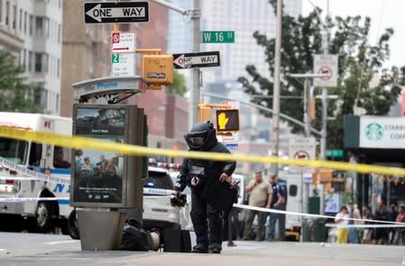 A NYPD Bomb Squad officer investigates suspicious packages near West 16th Street and Seventh Avenue as police were investigating suspicious packages in Manhattan