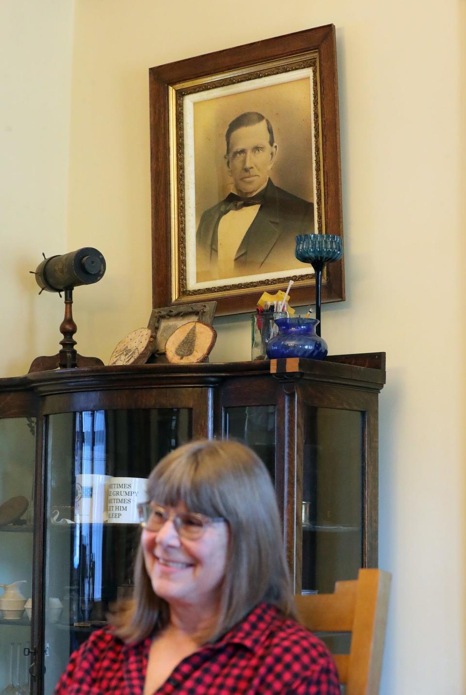 A portrait of founder Lawson Waterman appears to watch as his descendant Carol Haramis discusses the history of Heritage Farms.