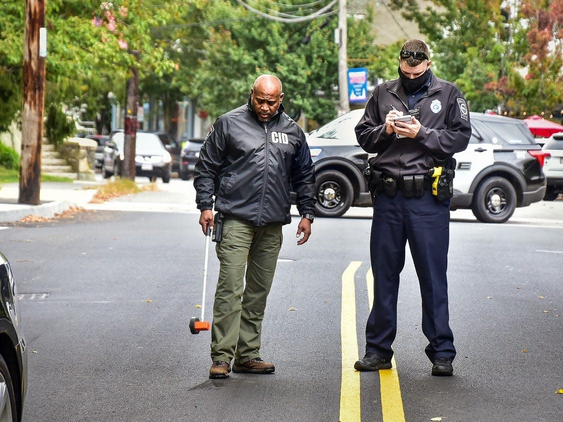 Detective Lt./CID Commander Michael Lopes and Officer Gregory Lowrance investigate the scene of an incident Friday, Oct. 16 where a pedestrian was struck by a motor vehicle on North Main Street.