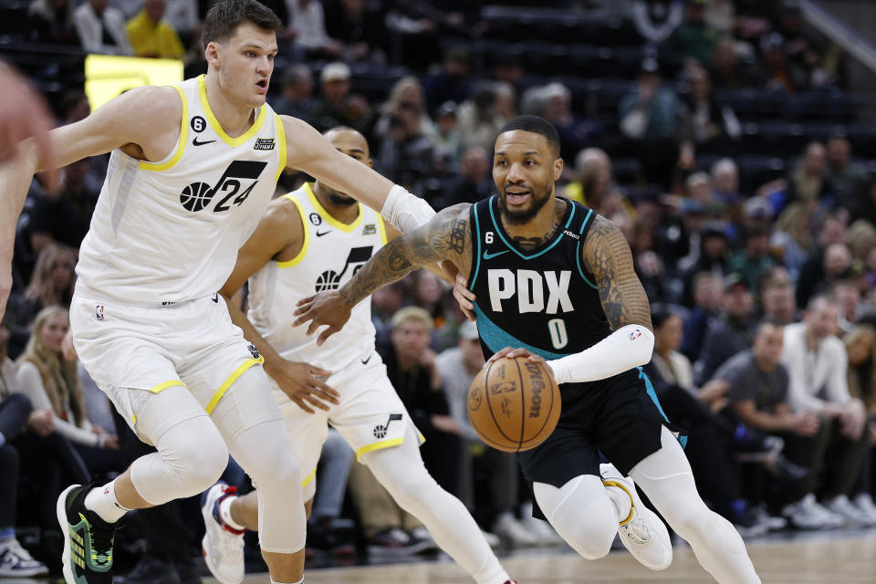 Portland Trail Blazers guard Damian Lillard (0) drives past Utah Jazz center Walker Kessler (24) in the first half during an NBA basketball game, Wednesday, March 22, 2023, in Salt Lake City. (AP Photo/Jeff Swinger)