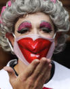 An actor dressed as a pantomime dame poses for photographers as they march on Parliament to demand more support for the theatre sector amid the COVID-19 pandemic in London, Wednesday, Sept. 30, 2020. (AP Photo/Frank Augstein)