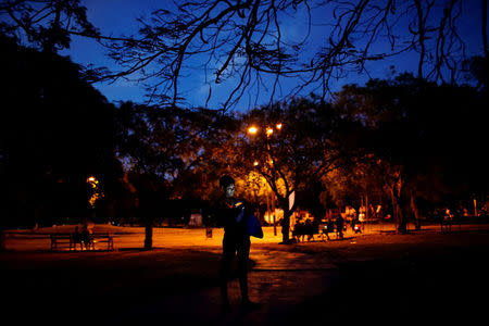 Piano teacher Claudia Suarez, 28, uses the internet at a hotspot in a park in Havana, Cuba, April 5, 2018. REUTERS/Alexandre Meneghini