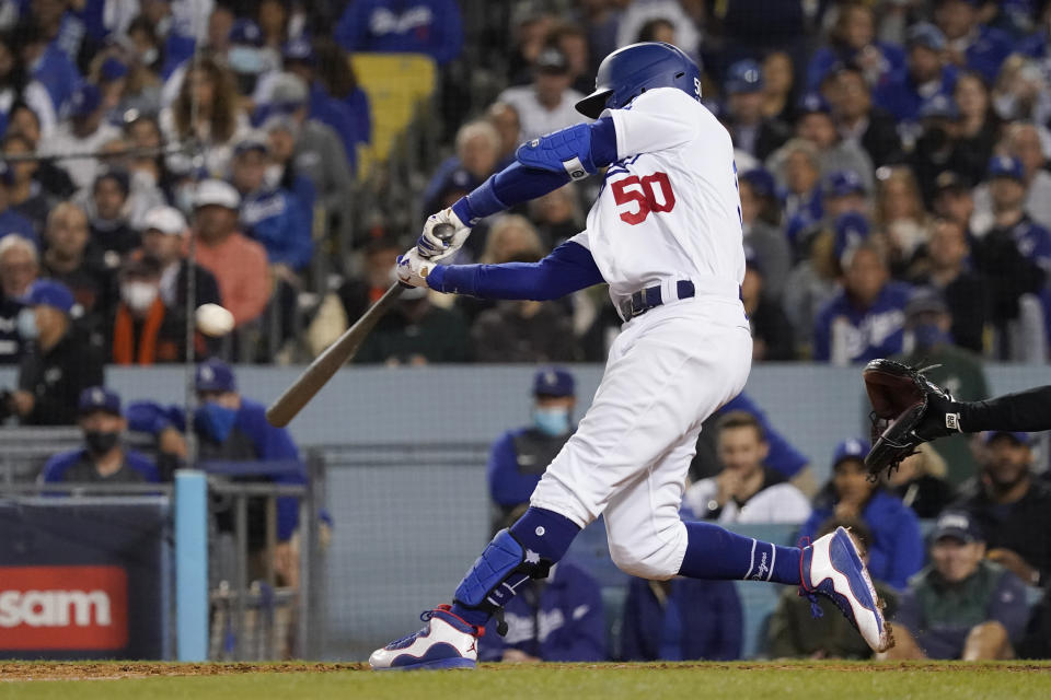 Los Angeles Dodgers' Mookie Betts hits a two-run home run during the fourth inning against the San Francisco Giants in Game 4 of a baseball National League Division Series, Tuesday, Oct. 12, 2021, in Los Angeles. (AP Photo/Marcio Jose Sanchez)