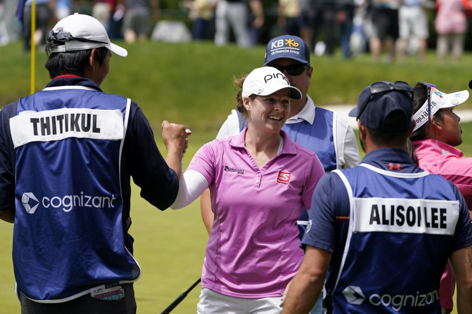 Ally Ewing, center, smiles on the 18th green after finishing her first round of the LPGA Cognizant Founders Cup golf tournament, Thursday, May 12, 2022, in Clifton, N.J. (AP Photo/Seth Wenig)