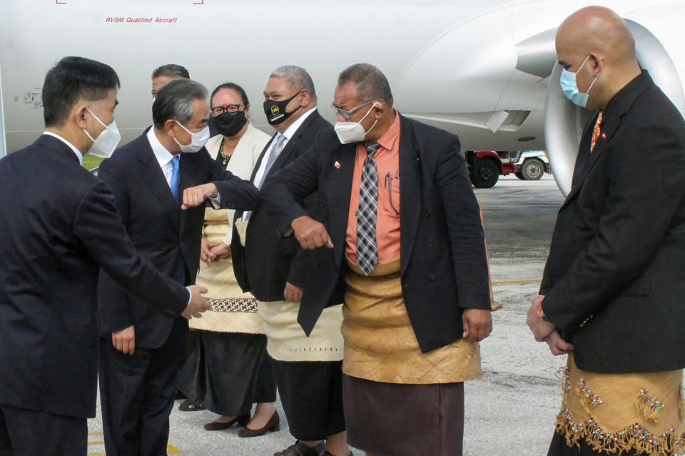 China's Foreign Minister Wang Yi, second left, is welcomed on the tarmac by officials on his arrival in Nuku'alofa, Tonga, Tuesday, May 31, 2022. Wang and a 20-strong delegation are in Tonga as part of an eight-nation Pacific Islands tour that comes amid growing concerns about Beijing's military and financial ambitions in the South Pacific region. (Marian Kupu/ABC via AP)
