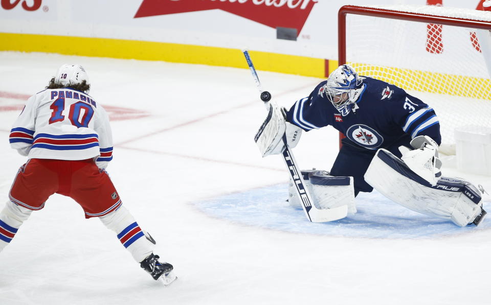 Winnipeg Jets goaltender Connor Hellebuyck (37) saves the breakaway shot from New York Rangers' Artemi Panarin (10) during the first period of an NHL hockey game Friday, Oct. 14, 2022, in Winnipeg, Manitoba. (John Woods/The Canadian Press via AP)