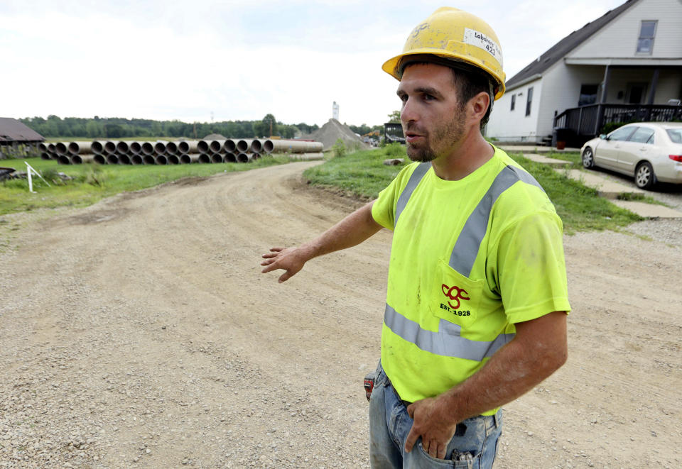 Taylor Purdy, a pipe layer with Complete General Construction, answers questions about his experience working around the new Intel semiconductor manufacturing plant construction site in Johnstown, Ohio, during an interview near the site Friday, Aug. 5, 2022. Purdy spends his days in trenches helping position storm and sanitary sewers and waterlines. Overtime is plentiful as deadlines approach. (AP Photo/Paul Vernon)