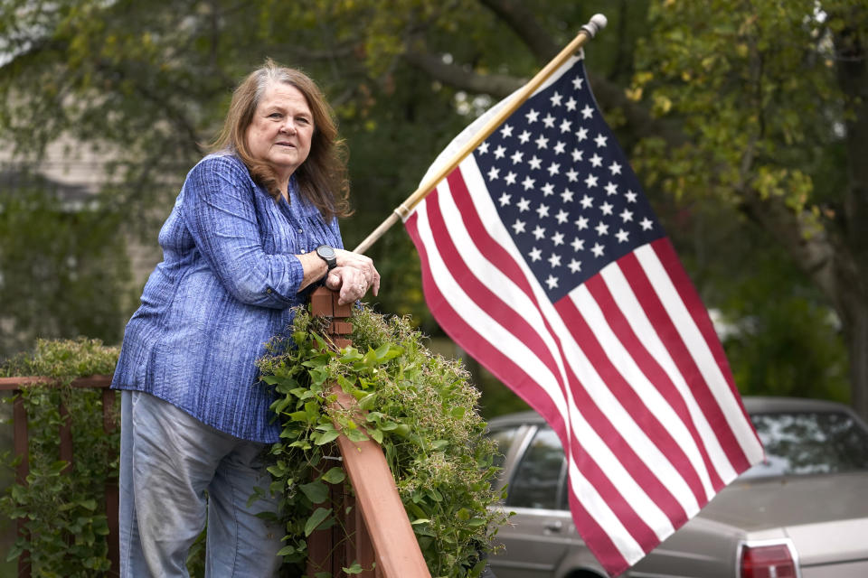 In this Saturday, Oct. 17, 2020, photo Cathy Badalamenti poses for a portrait at in her Lombard, Ill., home. Badalamenti has also struggled with her vote once again. In 2016, the Independent eschewed both Trump and Clinton and voted for a third-party candidate, despite having voting twice for former president Barack Obama. (AP Photo/Charles Rex Arbogast)