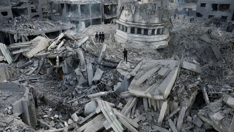 Palestinians inspect the rubble of the Yassin Mosque, destroyed after it was hit by an Israeli airstrike. - Adel Hana/AP