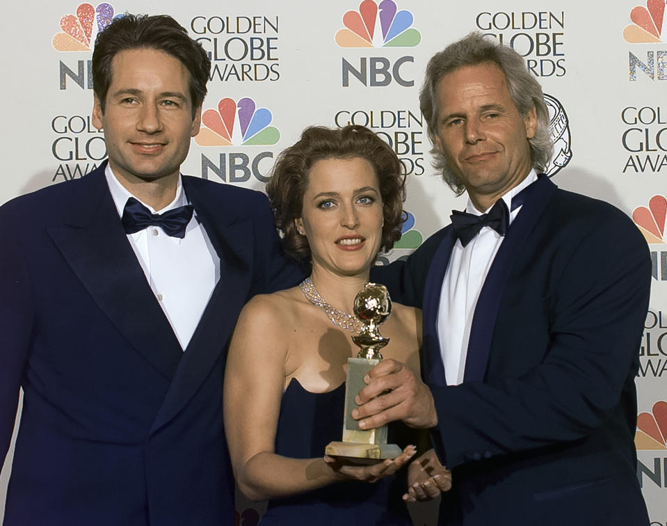 BEVERLY HILLS, CALIFORNIA - JANUARY 19: X-Files Chris Carter joins cast members Gillian Anderson and David Duchovny backstage at Golden Globe Awards Show, January 19, 1997 in Beverly Hills, California. (Photo by Bob Riha, Jr./Getty Images)