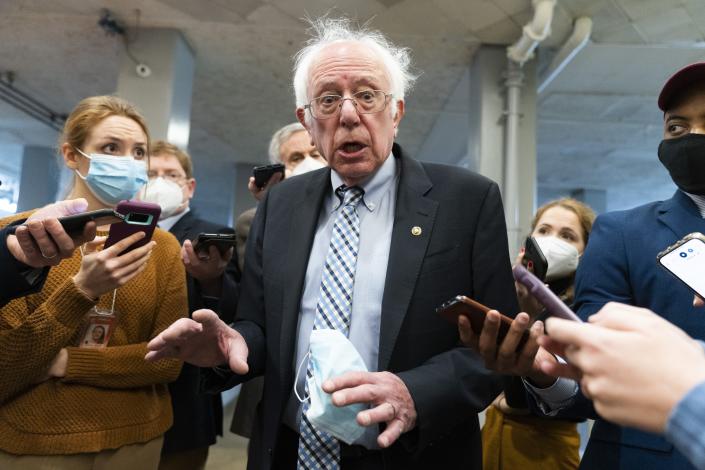 FILE - Sen. Bernie Sanders, I-Vt., makes comments to reporters about Sen. Joe Manchin, D-W.Va., as he walks to the Senate Chamber for a vote, on Dec. 15, 2021, in Washington. Just over a year ago, millions of energized young people, women, voters of color and independents joined forces to send Joe Biden to the White House. But 12 months after he entered the Oval Office, many describe a coalition in crisis.(AP Photo/Jacquelyn Martin, File)