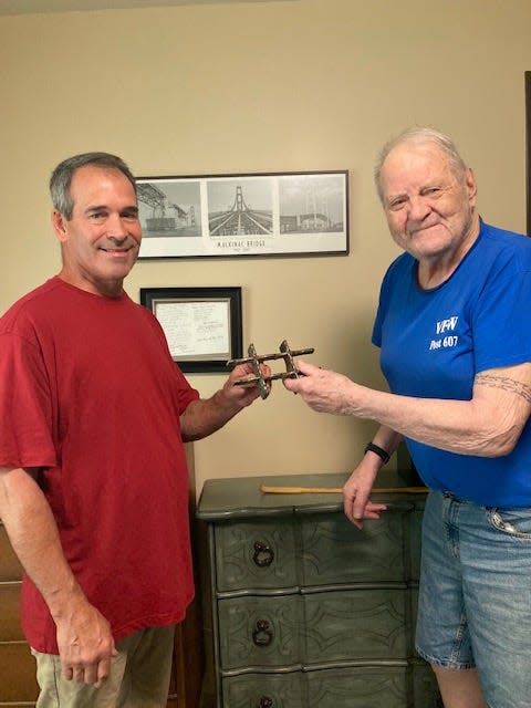 Jack R. Thompson (right), who worked on the Mackinac Bridge in 1956, receives a piece of the bridge's original steel grating from Bill O'Neil, maintenance director of the Besser Senior Living Community where Thompson now lives.