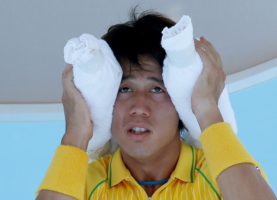 Kei Nishikori of Japan wraps an ice pack around his head during a break in his first round match against Marinko Matosevic of Australia at the Australian Open tennis championship in Melbourne, Australia, Tuesday, Jan. 14, 2014.(AP Photo/Aaron Favila)