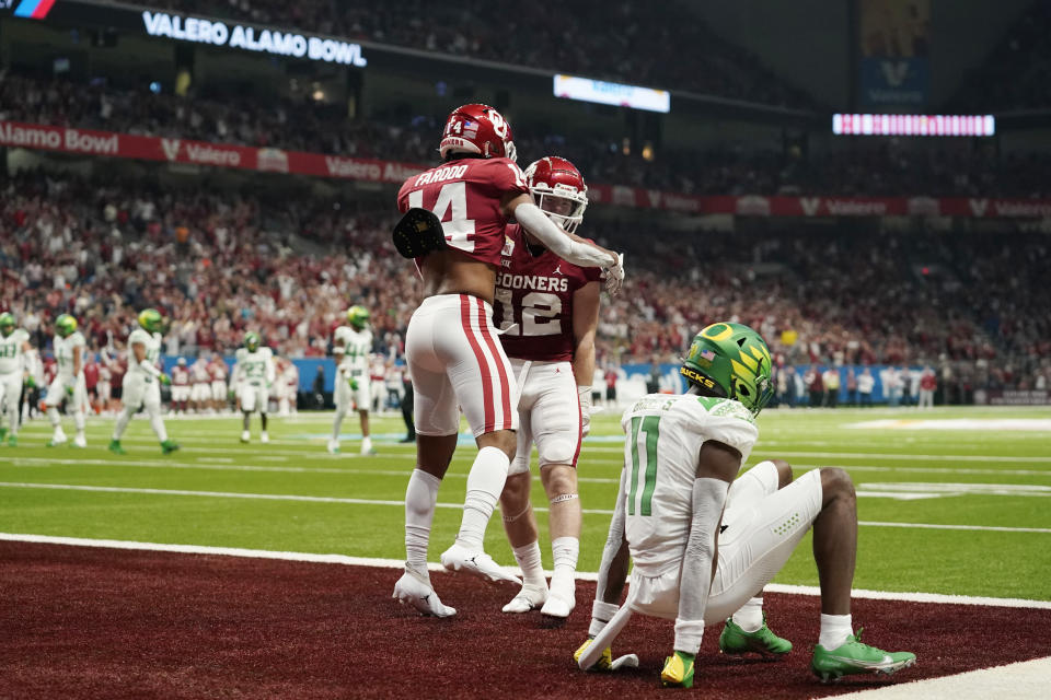 Oklahoma wide receiver Drake Stoops (12) celebrates with Jalil Farooq (14) after making a touchdown catch over Oregon cornerback Trikweze Bridges (11) during the first half of the Alamo Bowl NCAA college football game Wednesday, Dec. 29, 2021, in San Antonio. (AP Photo/Eric Gay)