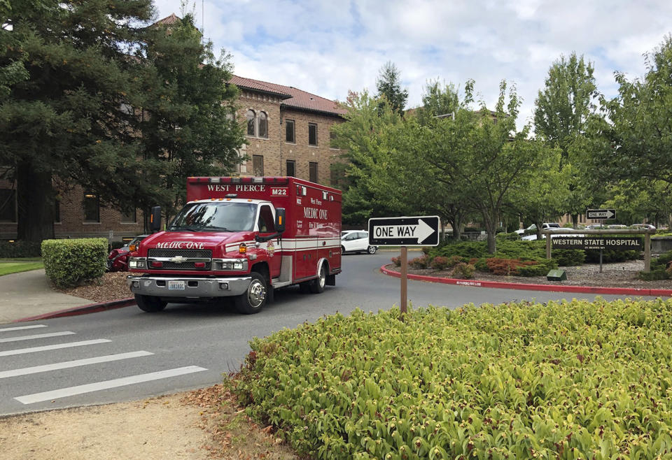 An ambulance leaves Western State Hospital in Lakewood, Wash., Thursday, Aug. 30, 2018. Workers at the psychiatric hospital were rallying Thursday to demand changes to the way officials assign dangerous patients to wards. (AP Photo/Martha Bellisle)