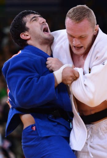 Germany's Dimitri Peters (white) competes with Russia's Tagir Khaibulaev (blue) in the men's -100kg judo semi-final at the London Olympics. The pair were watched by British Prime Minister David Cameron and Russian President Vladimir Putin