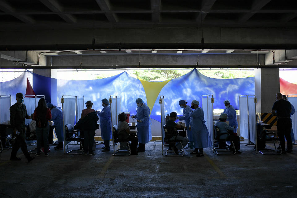 Healthcare workers prepare doses of the Sputnik V vaccine for COVID-19 as seniors and those considered high risk for contagion are eligible at a vaccination center set up in the parking lot of the Armed Forces Social Prevision Institute (IPSFA) in Caracas, Venezuela, Monday, June 7, 2021. (AP Photo/Matias Delacroix)